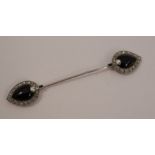 An onyx and diamond jabot pin, the palmette onyx cabochon enclosed by rose cut diamonds, a small