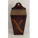 An Antique oak candle box, of tapered rectangular form with sloping hinged lid, the front inlaid