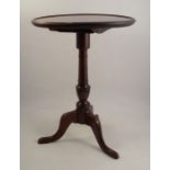 A late Georgian mahogany circular dish top table, raised on a column, terminating in a tripod