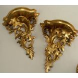 A pair of Italian gilt wood wall brackets, the shaped shelf supported by scrolling leaves, height