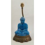 A table lamp, formed as a blue seated oriental deity, raised on a wooden base, height 13insCondition