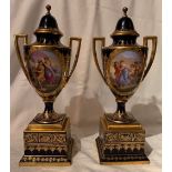 A pair of Viennese covered vases on pedestals, decorated with classical reserve panels to a blue and
