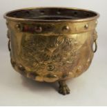 A Dutch style brass jardiniere, with lions mask and ring handles and floral panels, raised on