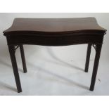 A late Georgian mahogany Serpentine fold over card table, raised on moulded chamfered legs with fret