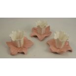 A set of three Graingers Worcester lily leaf centre pieces, the white flower raised on a pink