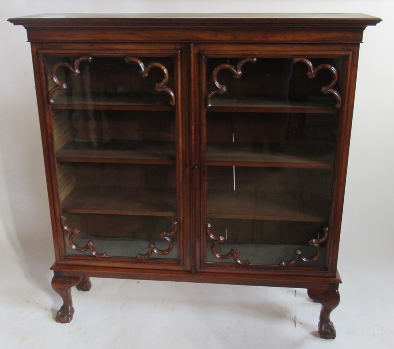 A 19th century mahogany display cabinet, having two glazed doors with scroll moulded spandrels,