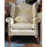 A Georgian design wing armchair, on short cabriole legs, with yellow floral upholstery, Condition