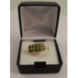 A ten stone emerald ring, set in two rows of five in unmarked yellow gold, tests as 18 carat gold,