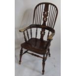 A Windsor armchair, with a pierced central splat, flanked by turned spindles to a saddle seat, the