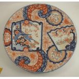 A large Imari charger, decorated in the typical palette with foliage to an iron red ground, under-