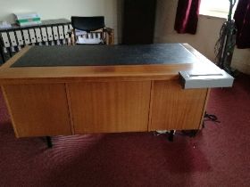 A modern office knee hole desk with leatherette inset top, flanked by four graduated drawers to each