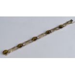 A 9 carat gold tiger eye bracelet, the five cabochons with pierced panels between, 19cm long, 16g