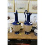 A PAIR OF ROYAL DOULTON EWERS, STAMPED TO THE BASE, HEIGHT 14INS