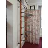A run of wall  mounted shop fittings, comprising 13 up-rights and a quantity of chrome hanging rails