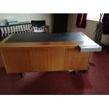 A modern office knee hole desk with leatherette inset top, flanked by four graduated drawers to each
