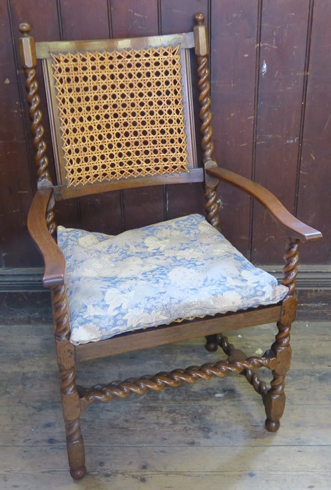 An antique Carolean style walnut bergere open armchair, with all over barley twist turnings and