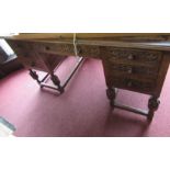 An oak knee hole writing desk, fitted with a frieze drawer flanked by three drawers to each side,