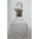 A silver mounted cut glass decanter, of bulbous form, with silver collar and glass stopper,