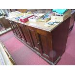 A mahogany counter, having three pairs of two fielded panel doors to the front, raised on a plinth