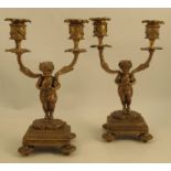 A pair of 19th century gilt metal candelabra, formed as two Classical figures holding a pair of