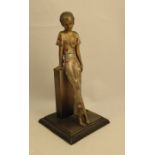 A Lorenzl patinated spelter table lighter, modelled as a woman wearing a flower trouser suit leaning