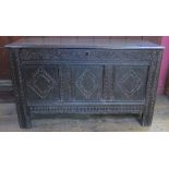 An 18th century oak coffer, having three lozenge carved panels to the front below a plain rising