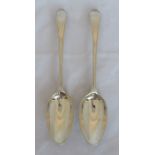 A pair of mid 18th century silver serving spoons, with feather edge and engraved with initials,