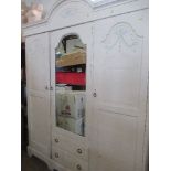 A PAINTED TRIPLE DOOR WARDROBE, THE CENTRAL ARCHED MIRROR CUPBOARD HAVING A PULL-OUT TRI-FOLD