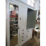 A PAINTED THREE DOOR CUPBOARD, HAVING MIRROR DOOR HANGING SPACE TO THE LEFT, A CENTRAL SHELF UNIT