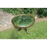 A mirror top circular table, with painted black and gold decoration to the edge and base, diameter