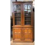 A large 19th century oak cabinet, the upper section having a pair of glazed doors, the base fitted