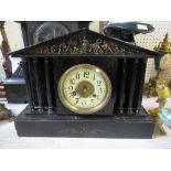 A 19th century black slate mantel clock, of architectural form, decorated with classical battle
