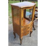 A French style display cabinet, with glazed bow front display cupboard over two drawers, with gilt