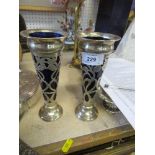 A pair of hallmarked silver vases, with blue glass liners