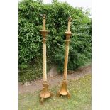 A pair of gilt wood floor standing candle holders, with velvet covered columns, converted to