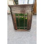 An Antique style oak corner cupboard, with stained glass door