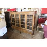 An oak glazed bookcase, fitted with two pairs of glazed doors opening to reveal adjustable