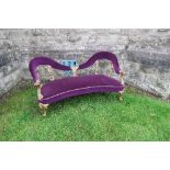 A Victorian style two seater settee, with open arms and gilt decoration with purple upholstery,