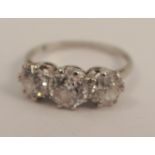 A three stone diamond ring, the white mount unmarked, the graduated old brilliant cuts totalling