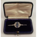 A diamond and sapphire bar brooch, with a vertical line of three graduated sapphires within a
