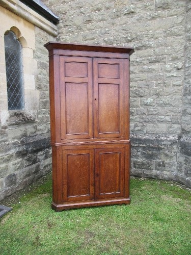 A Georgian oak freestanding double corner cupboard