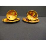 Two miniature Royal Worcester tea cups and saucers, decorated with hand painted fruit by