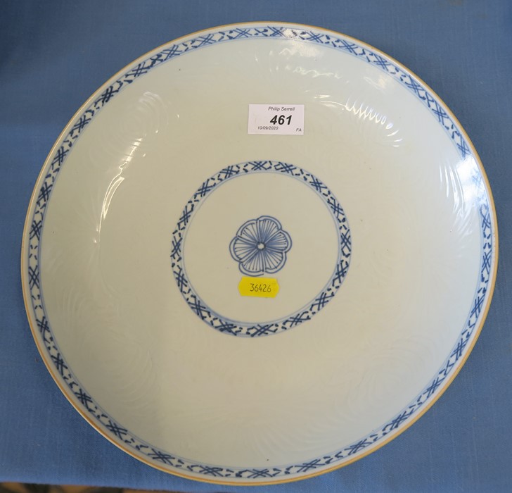 A Chinese saucer dish, decorated with blue bands around a central floral motif, having moulded body,