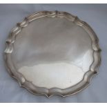 A silver salver, with shaped edge, raised on three knurl feet, Birmingham 1976, weight 35oz,