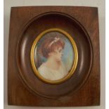 A 20th century portrait miniature, of a girl in profile, signed, maximum diameter 2.5ins