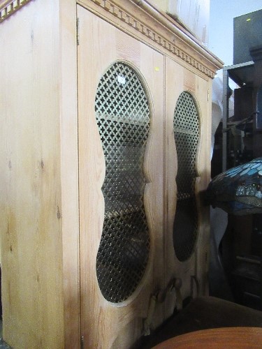 A pine cupboard, having two doors with Eastern style metal grill , opening to reveal shelves,