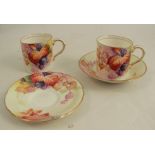 Two Royal Worcester coffee cans and two saucers, decorated with Autumnal fruits and leaves by M