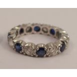 A diamond and sapphire eternity ring, in unmarked white metal, alternate set with eight brilliant
