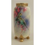 A Royal Worcester spill vase, decorated with two budgerigars and flowers, raised on four scrolling