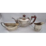 A silver three piece tea set, with gadrooned lower body and embossed leaves to the handles,